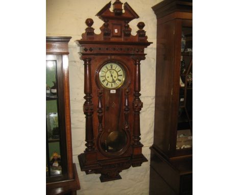 Large early 20th Century walnut Vienna style wall clock having turned and carved broken arch pediment above a circular dial w