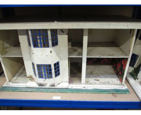 A vintage wooden two tier dolls house having tin plate windows