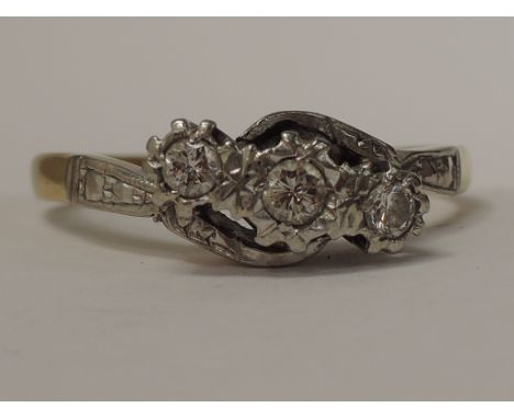 A ladies dress ring having three diamonds in a crossover setting on a yellow metal loop stamped 18ct &amp; Plat