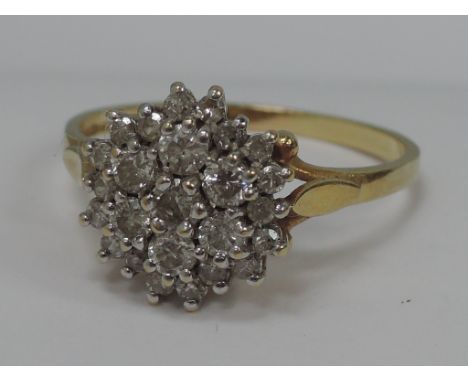 A ladies dress ring having a diamond triple cluster in a raised claw setting on an 18ct gold loop