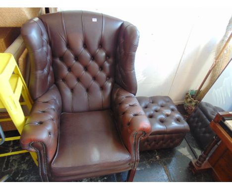 A leather button back wing armchair and stool