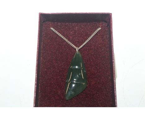 A jade coloured pendant hung to fine link chain