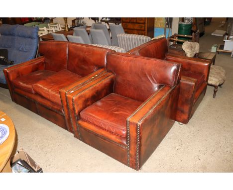 A vintage leather upholstered three piece suite comprising of two seater settee and two matching armchairs 