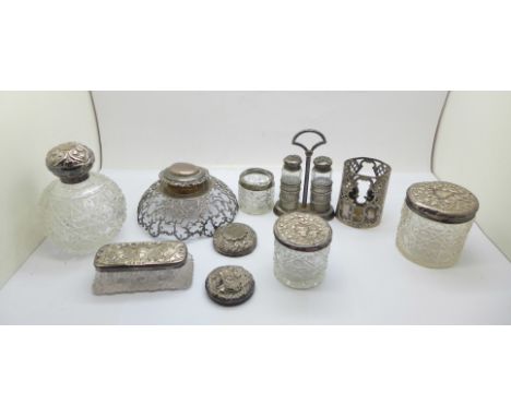 A silver topped globular glass scent bottle, three other silver topped jars, one with silver rim, a silver two bottle salt an