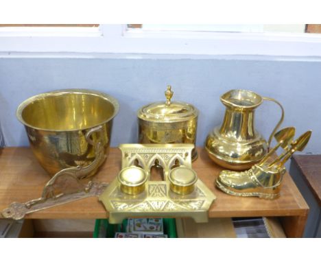 A collection of brass, a tea caddy, heavy jug, jardiniere, double ink stand, coat hook and novelty boot with garden tools 
