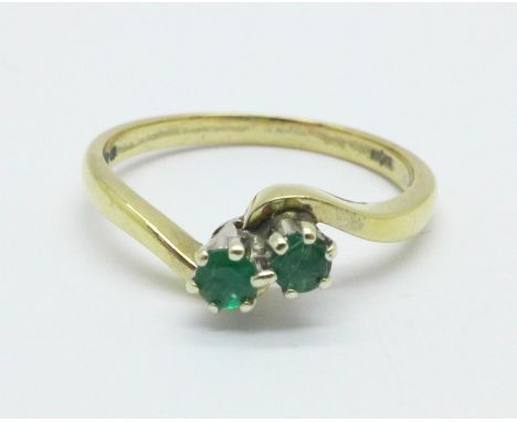 A 9ct gold, two stone emerald ring, 1.9g, K 