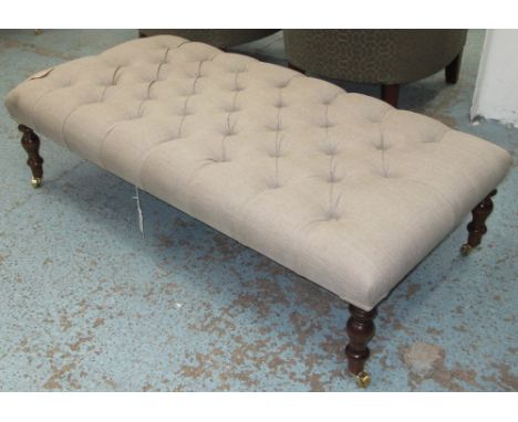 HEARTH STOOL, in taupe linen buttoned upholstery on turned supports and castors, 123cm x 63cm.