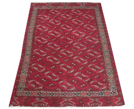 FINE TEKKE CARPET, 266cm x 183cm, repeat gul decoration on a ruby field inside a corresponding geometric border. 