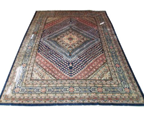 FINE KHOTAN CARPET, 402cm x 292cm, layered floral medallions in various shades of blue, ivory and pink inside multiple corres