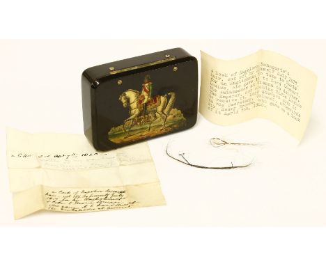 Napoleon Bonaparte: a small lacquered box,19th century, the lid decorated with Napoleon on horseback, containing a lock of ha