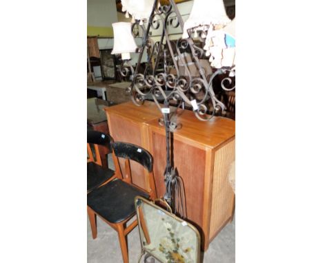 A wrought iron lamp standard and a painted mirror firescreen