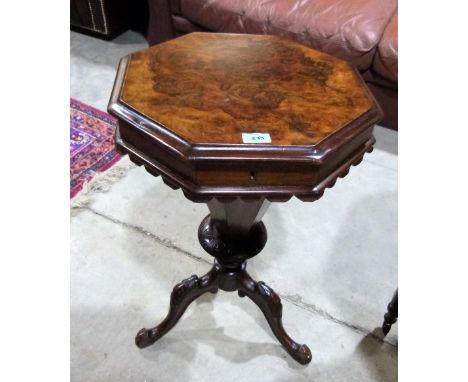 A Victorian walnut trumpet work table with octagonal lid enclosing fitted interior on tripod support