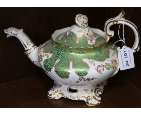 A 19th century china teapot, gilded green with floral decoration Condition: cracks to body of pot in a few places, no visible