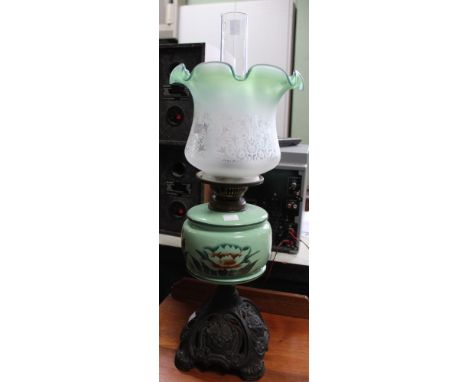 A Victorian metal based oil lamp with porcelain reservoir and glass shade and funnel