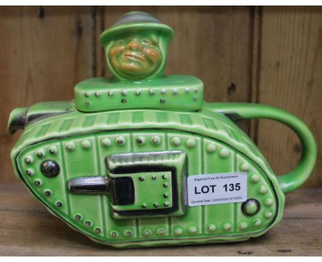 A ceramic teapot modelled as a First World War tank, the lid knop in the form of an "Old Bill" character, green glazed