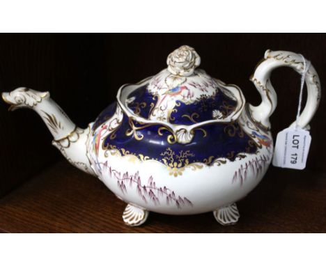 A 19th century china teapot, gilded blue with fancy bird decoration, raised on scallop feet Condition: Some gilt wear, a chip