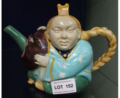 A MInton majolica ceramic "Chinaman" teapot, modelled as a seated figure, his hair plait as the handle, nursing a grotesque m