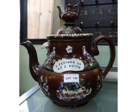 A late Victorian "Bargee" teapot, treacle glazed with applied decoration including the panel inscribed "A present to Mr J Smi