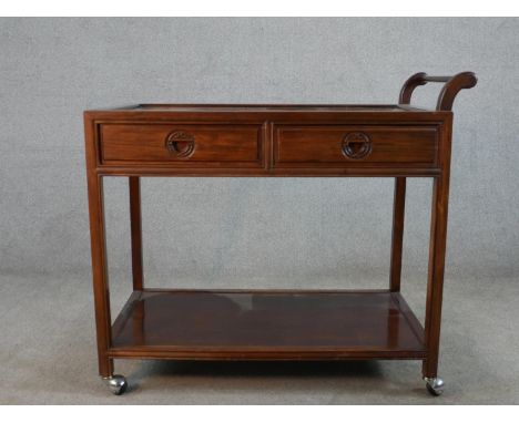 A mid 20th century Chinese hardwood, (possibly cherrywood), two drawer trolley with shelf below, raised on casters. H.86 W.91