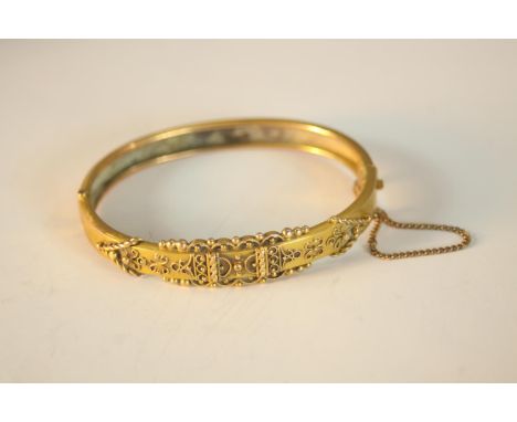 A Victorian yellow metal (tests as 9ct) Etruscan style filigree wire work clip bangle with safety chain. W.6.5 D.5.5cm. Weigh