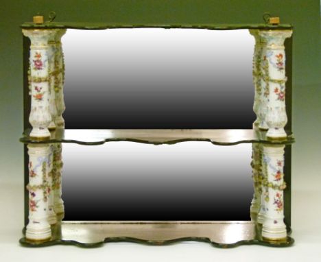 Ebonised mirror back three tier wall bracket, the shaped front shelves supported by floral encrusted and painted German porce
