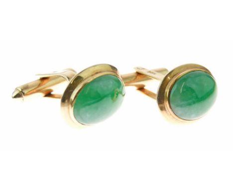Pair of jade cufflinks, the oval cabochons approximately 14.5mm long, to a yellow mount stamped '14k', untested and unwarrant