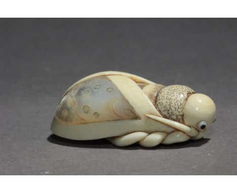 A Japanese netsuke from Showa-Heisei period. Signed on the base. In carved bone, mother of pearl and glass inlaid portraying 