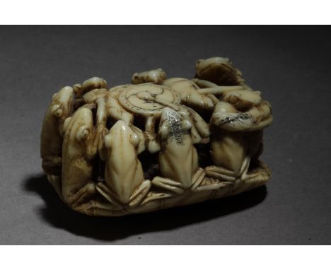 A Japanese netsuke from Edo period circa 1820-1870. Signed Seimin on the base. In carved walrus tusk portraying a group of ni