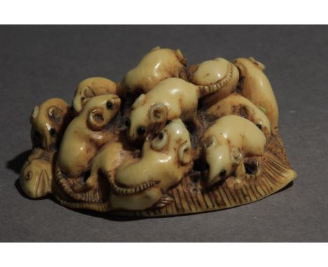 A mid 19th century Japanese netsuke from Edo period. Attributed to Masamitsu. In carved elephant tusk portraying a group od t