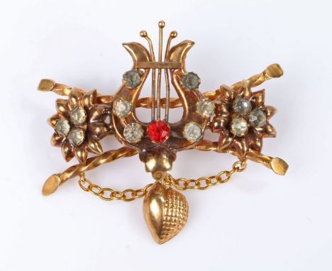 19th Century Yellow metal brooch, with a harp set with paste stone flanked by flower heads and twisted bars, 52mm diameter. 7