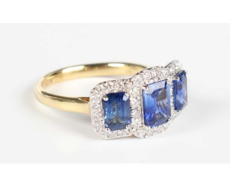 A gold, sapphire and diamond ring, claw set with three rectangular step cut sapphires, each within a surround of round brilli