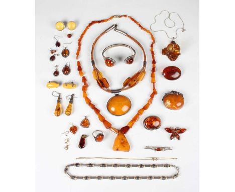 A collection of mostly reconstituted amber jewellery, comprising two necklaces, a bangle, a ring, two pendants, five brooches