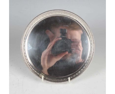 An Elizabeth II silver circular card salver with bellflower and beaded rim, on claw and ball feet, Sheffield 1979 by Garrard 