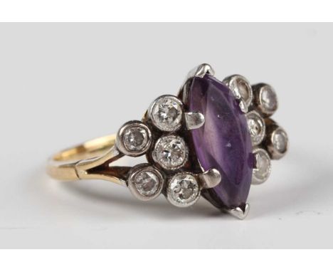 A gold, platinum, amethyst and diamond ring, claw set with a marquise shaped amethyst between collet set diamond five stone s