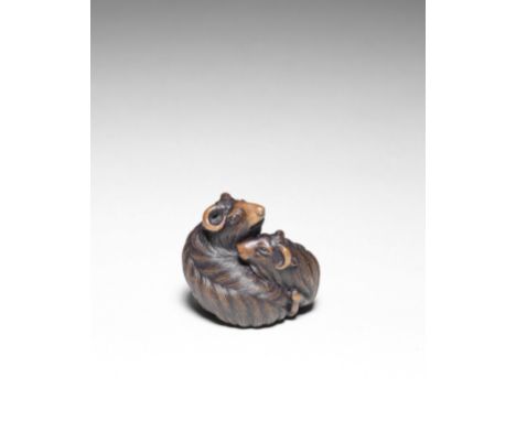 NETSUKE EN BOIS REPRÉSENTANT DEUX CHÈVRESXIXe siècleA WOOD NETSUKE OF TWO GOATS19th centuryThe two goats seated and nestled a