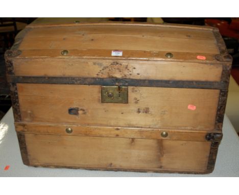 A Victorian pine and iron bound dome top trunk flanked by iron handles 