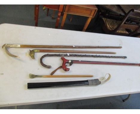 Four walking sticks to include one with silver mounts together with a black painted truncheon and a back scratcherLocation: 6