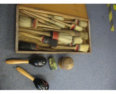 A vintage treen storage box with a Spanish exporters label, containing vintage pure bristle brushes together with a pair of m