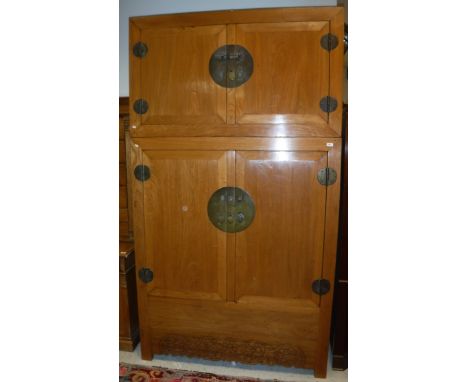 A modern Chinese elm wardrobe with two cupboard doors over two further cupboard doors enclosing shelf, two small drawers and 