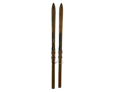 TWO PAIRS OF VINTAGE SKIS, ALONG A PAIR OF SKIING POLES and three golf clubs