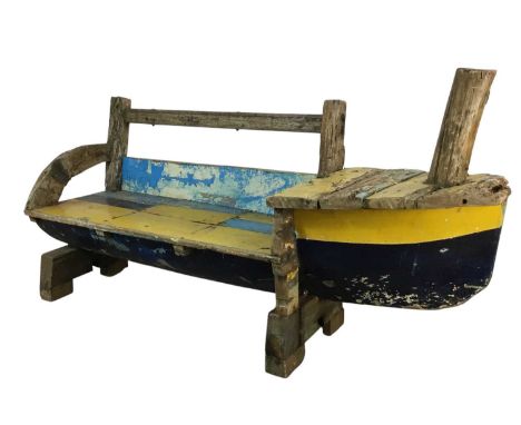 UNUSUAL WOODEN GARDEN BENCH, formed from a boat's hull and driftwood, with hinged compartment110cm high, 204cm wide