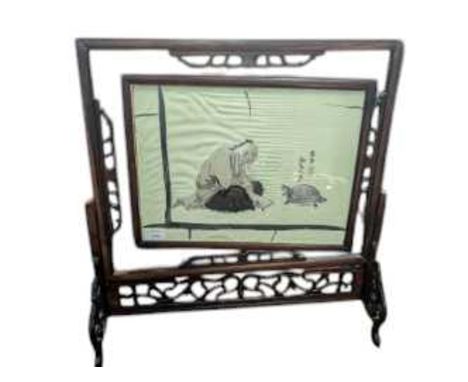 CHINESE TABLE SCREEN, EARLY 20TH CENTURY with rotating panel inset with a silk embroidery, depicting a figure chasing an anim
