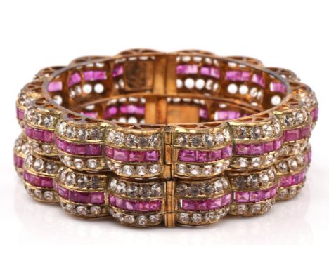 Two ruby and white sapphire hinged bangles, with a central row of calibre cut rubies, with a row of round cut white sapphires