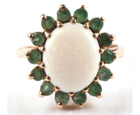 1970's Opal and emerald cluster ring, central opal cabochon measuring 12mm x 9mm, surrounded by fourteen mix cut emeralds, ri