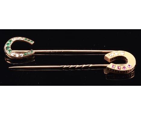 Two antique horse shoe stick pins, one set with graduated diamonds and cushion cut emeralds, measuring 68mm x15mm and another