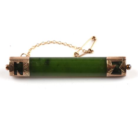 Jade nephrite bar brooch, with gold design terminals marked N Z, tested 9 ct gold measures 60mm x 7mm with a safety chainCond