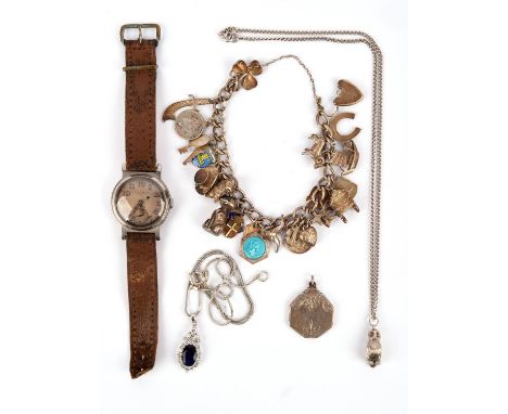 Silver charm bracelet with 25 charms including a pig, a Cheshire cat, a top hat, with a silver blue paste oval faceted pendan