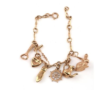 Gold charm bracelet with figure of eight links and seven charms, including a rabbit, a corkscrew and bottle opener, all in 9 