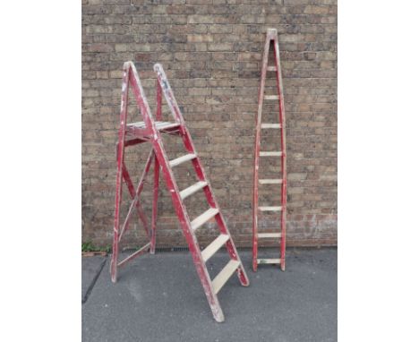 A VINTAGE WOODEN STEPLADDER painted red and a similarly painted wooden ladder extension (2)