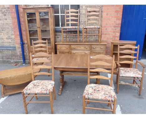 ERCOL: A MATCHED SUITE OF DINING FURNITURE comprising cabinet, extending table and six chairs (including two carvers), drop-f